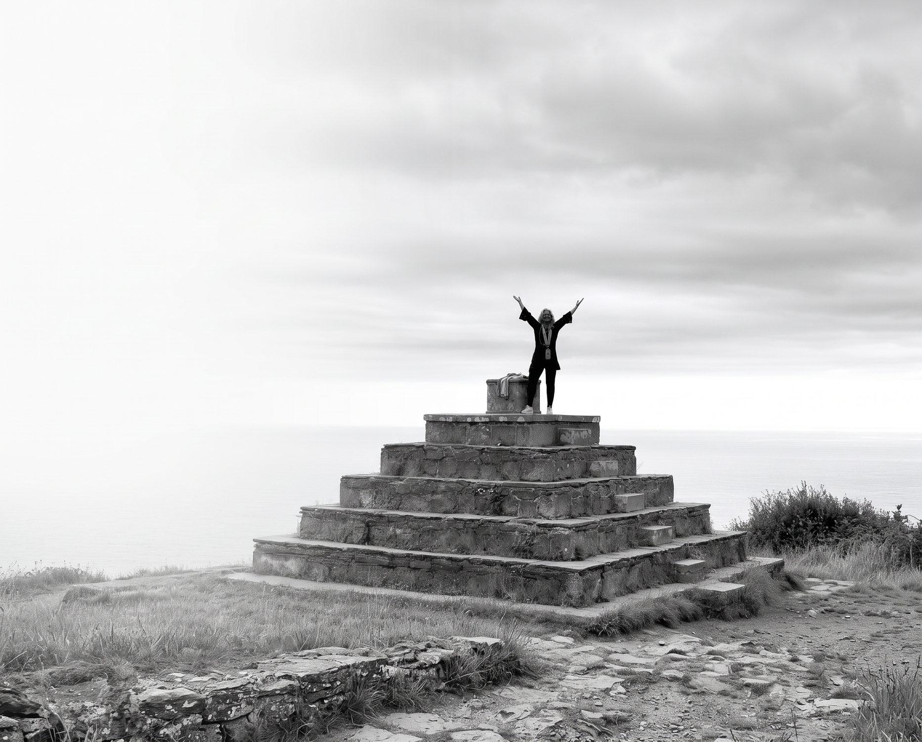 Elizabeth raising her arms on a temple overlooking the sea