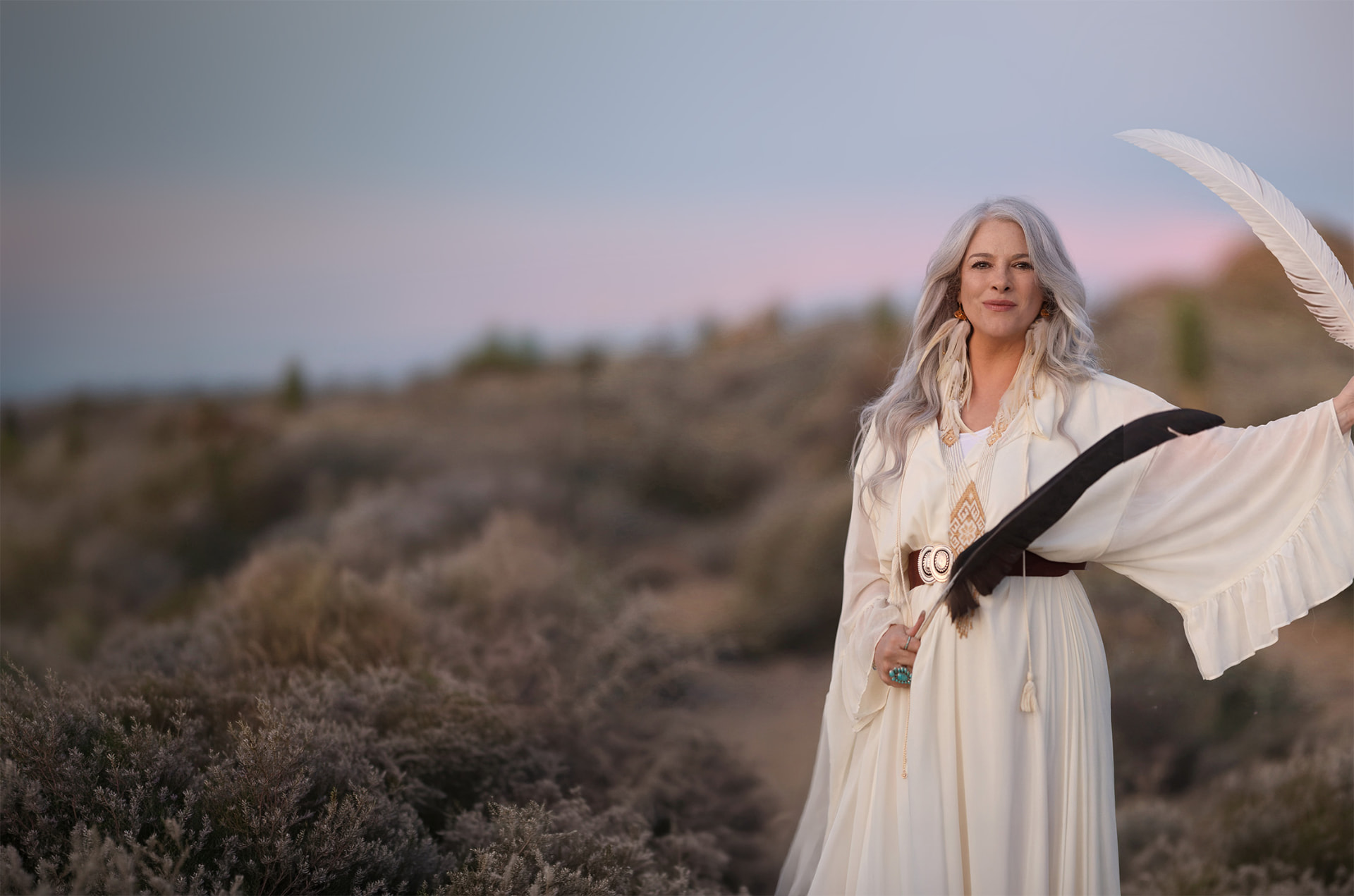 Elizabeth Arolyn Walsh holding ceremonial feathers